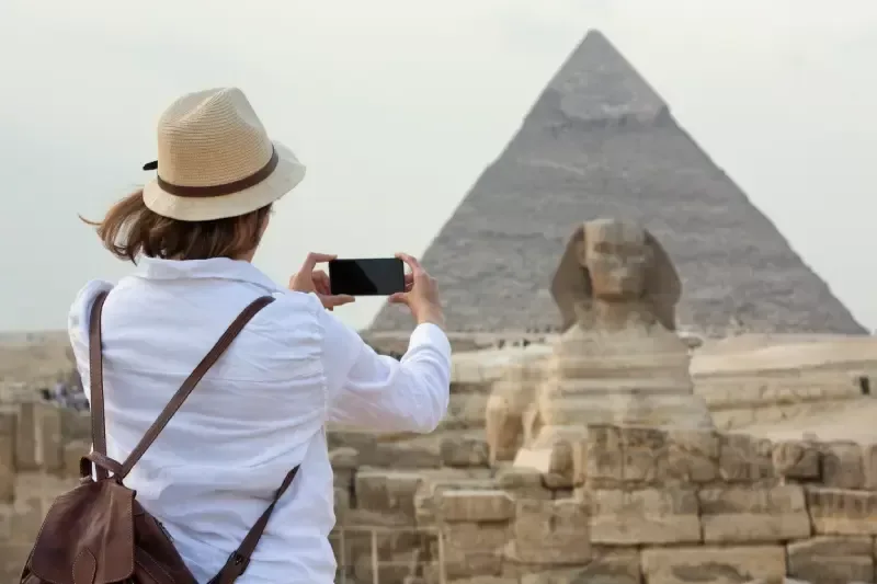 Una Donna Che scatta un foto alle piramidi, vacanze pasqua egitto